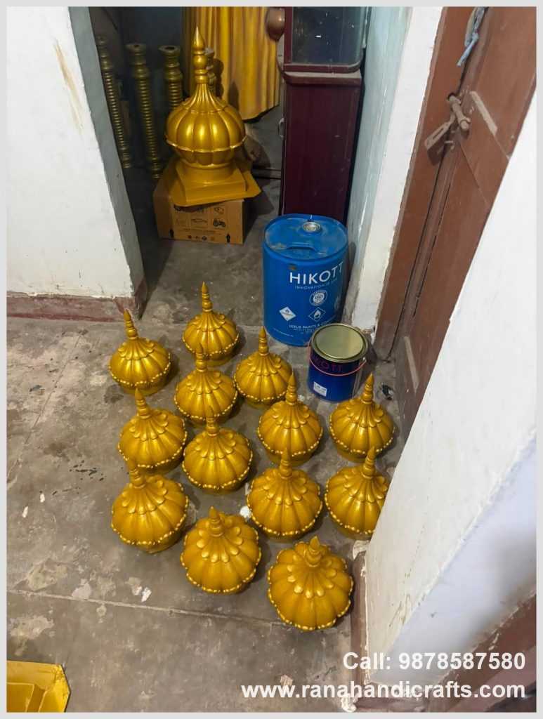 Collection of small golden domes for the UK, arranged on the workshop floor next to paint drums, made by Rana Handicrafts International using high quality silicon fiber