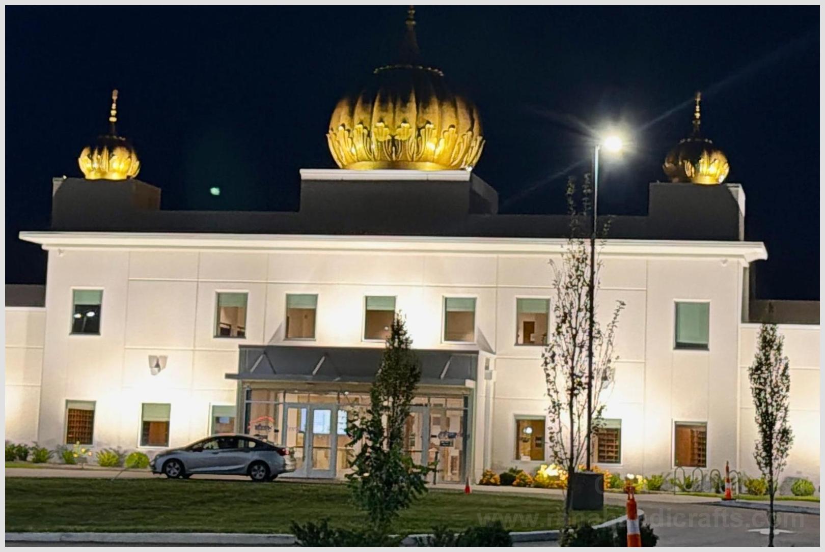 Night view of Sikh Satsang Gurdwara Sahib in Indianapolis USA with spotlights installed to brightly illuminate the golden main Gumbad and side domes