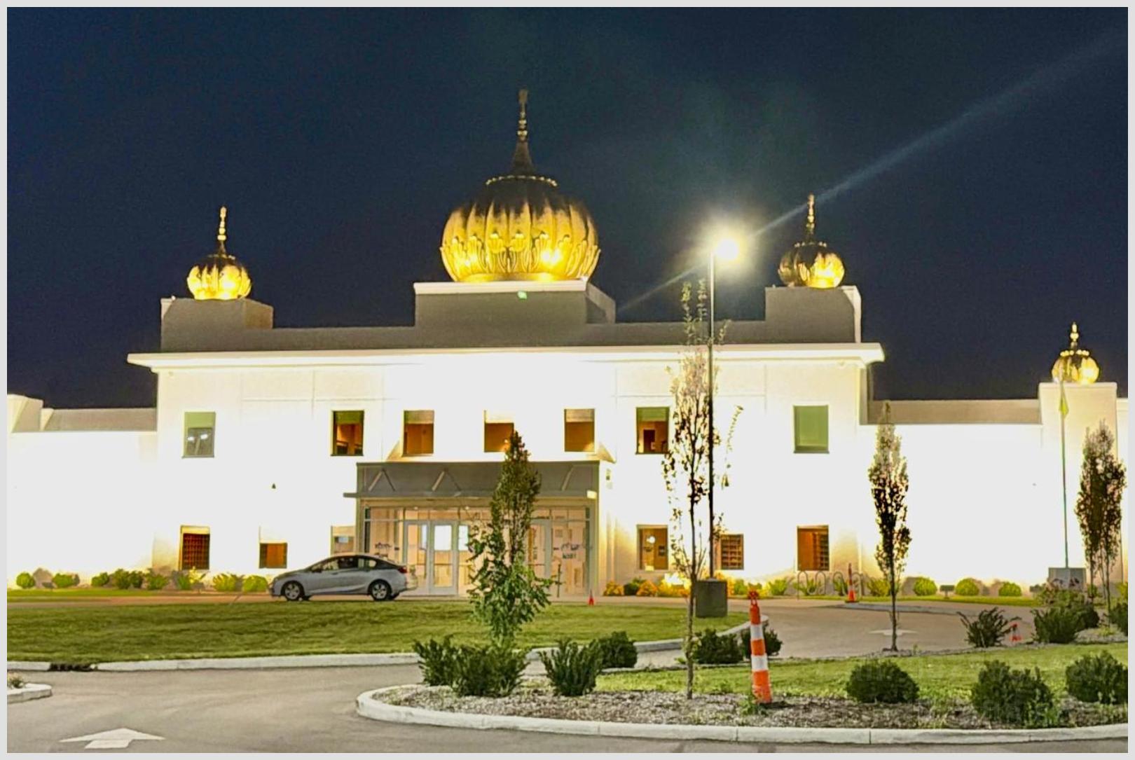 Illuminated golden Gurdwara Sahib domes glowing at night under focused exterior spotlights at Sikh Satsang of Indianapolis