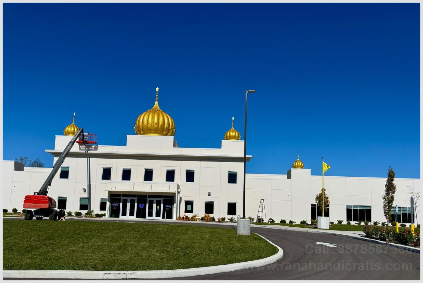 Installation of handcrafted golden domes on Gurdwara Sahib roof using hydraulic boom lift by local Sikh Sangat